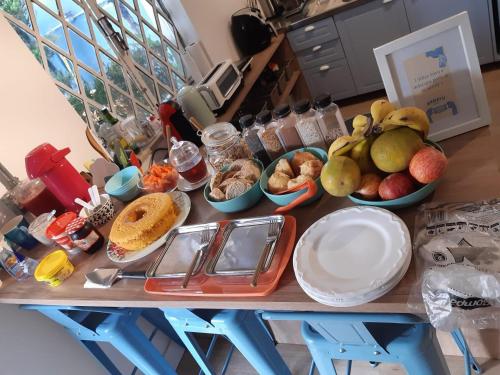 una mesa cubierta con tazones de frutas y otros alimentos en Angatu Hostel, en São Paulo