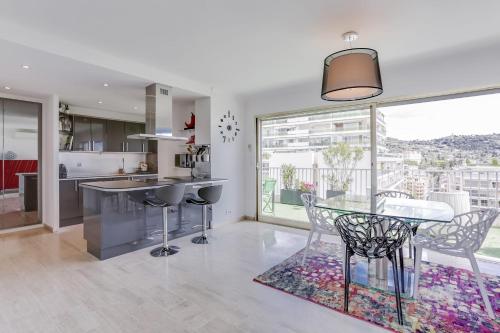 een keuken en eetkamer met een tafel en stoelen bij IMMOGROOM - Apartment with terrace - AC - Parking in Cannes