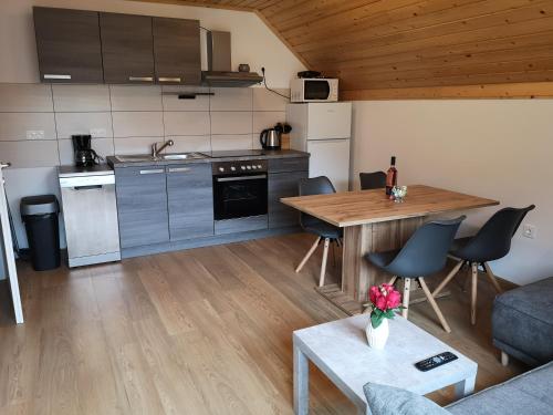 een keuken en een woonkamer met een tafel en een bank bij Apartments Gaby in Gozd Martuljek