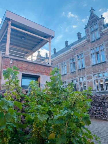 a brick building with a tree in front of it at Les chambres atypiques de Nico Bush - Parking sécurisé vélos in Tournai
