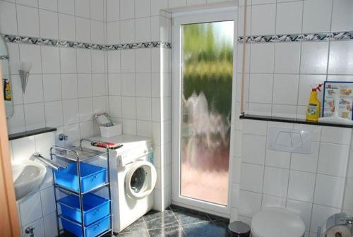 a washing machine in a bathroom with a window at Langenwerder in Kaltenhof