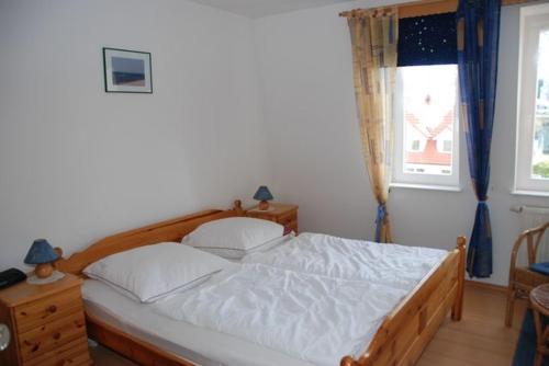 a bedroom with a bed and a window at Ostseeblick Ferienwohnung in Am Schwarzen Busch