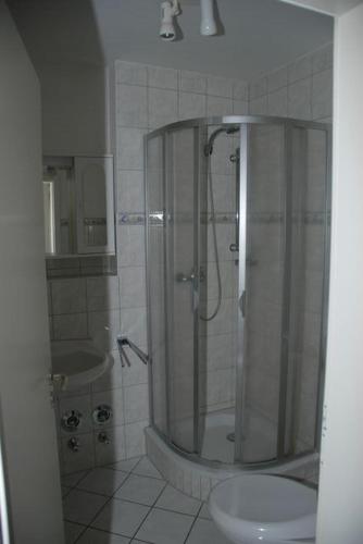 a bathroom with a shower with a toilet and a sink at Ostseeblick Ferienwohnung in Am Schwarzen Busch