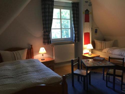 a bedroom with a bed and a table and a window at Möwennest in Am Schwarzen Busch