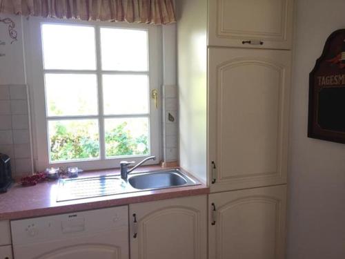 a kitchen with a sink and a window at Möwennest in Am Schwarzen Busch