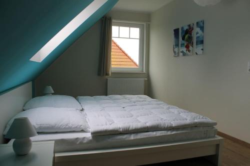 1 dormitorio con 1 cama blanca y ventana en Paul, en Kaltenhof