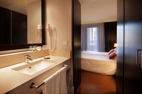 バルセロナにあるホテル コンダドのバスルーム(シンク、ベッド付)