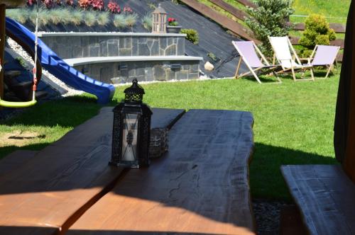 a lantern sitting on top of a table with a playground at Pokoje Goscinne Pieninska Parzenica in Mizerna