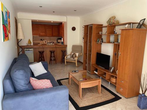 Il comprend un salon avec un canapé bleu et une cuisine. dans l'établissement Verde Ria apartamento, à Torreira
