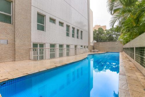 una gran piscina azul junto a un edificio en Vossa Bossa Pinheiros Style, en São Paulo