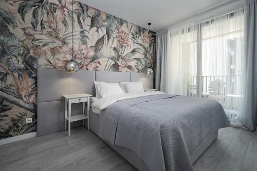 sypialnia z dużym łóżkiem i tapetą w kwiaty w obiekcie Apartament Pastelowa Portova w mieście Gdynia