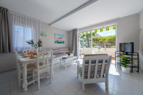 a white dining room with a white table and chairs at Apartamentos Estival Park in La Pineda