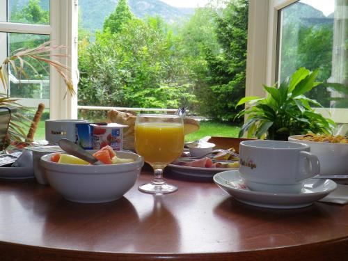 a table with food and a glass of orange juice at Hotel Amys Voreppe in Voreppe