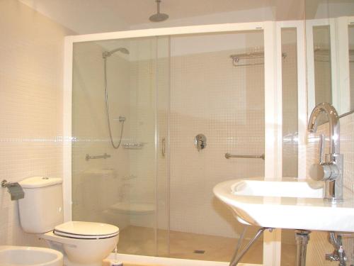 a bathroom with a shower and a toilet and a sink at Villa Mar in Cala en Blanes