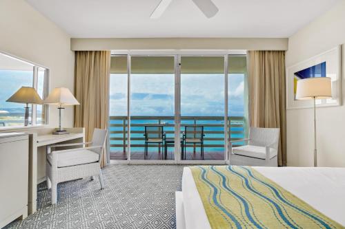 法哈多的住宿－El Conquistador Resort - Puerto Rico，酒店客房设有一张床和一张书桌,享有美景。