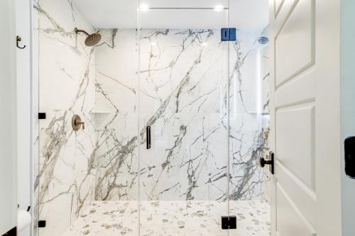 La salle de bains est pourvue d'une douche et de murs en marbre. dans l'établissement Lake Folly, à Folly Beach