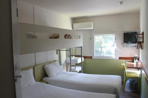 um quarto de hotel com duas camas e uma janela em ibis Budget - Melbourne Airport em Melbourne