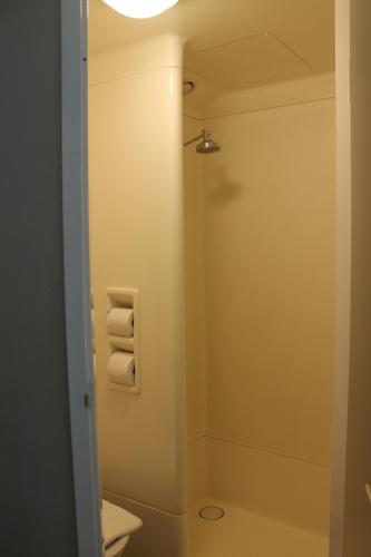 a bathroom with a toilet and a shower with towels at ibis Budget - Melbourne Airport in Melbourne