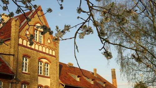 a large brick building with a red roof at FeWo "Falter" im Kunstgut Krahne in Krahne