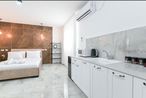 a white bedroom with a bed and a sink at Lake Mansion Boutique Apartments in Tiberias