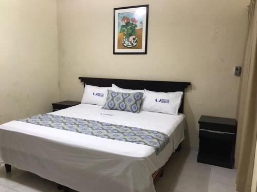 a bedroom with a large bed with white sheets and pillows at Hotel Dorado a una calle de Playa Regatas y el Malecon in Veracruz