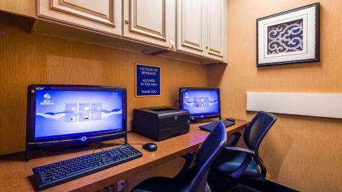 an office cubicle with two monitors and a computer on a desk at Best Western Plus Brandywine Inn & Suites in Monticello
