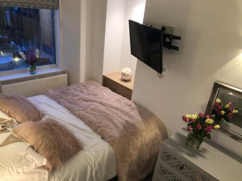 a bedroom with a bed and a flat screen tv at The Coop in Castle Douglas