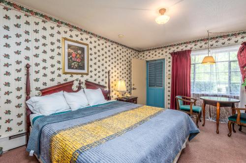 a bedroom with a bed with a blue and yellow blanket at Parkway Inn in Waynesville