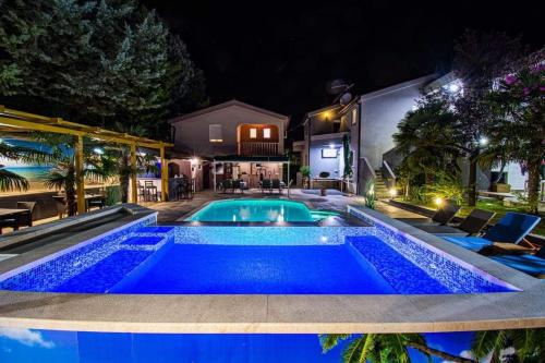 a swimming pool in a backyard at night at Guest House Milicevic in Ljubuški