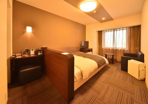 Habitación de hotel con cama y sofá en Dormy Inn Asahikawa en Asahikawa