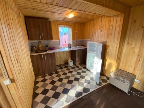 a kitchen with a checkered floor in a cabin at Ладога Новая in Vladimir