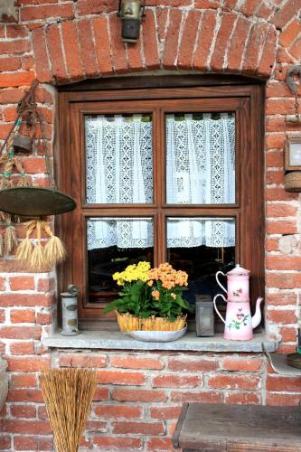 a window with two baskets of flowers on a window sill at Lu Garun Rus in Valdieri