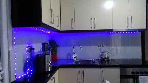 a kitchen with purple lights on a counter at Vila Reni Risi in Ksamil