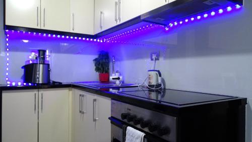 a kitchen with purple lights on top of a counter at Vila Reni Risi in Ksamil