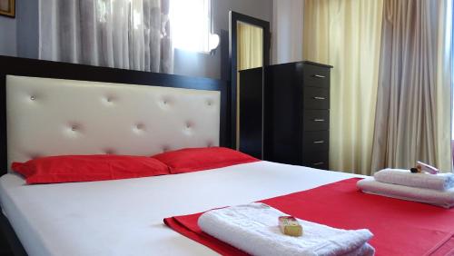a bedroom with a large bed with red and white towels at Vila Reni Risi in Ksamil