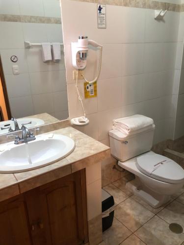 uma casa de banho com um lavatório, um WC e um espelho. em Awki´s Dream Hotel em Cusco