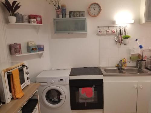 uma cozinha com uma máquina de lavar roupa e um lavatório em La Traboule Vieux Lyon em Lyon