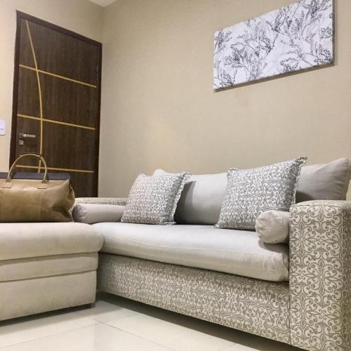 a couch with pillows on it in a living room at Flats Integração in Petrolina