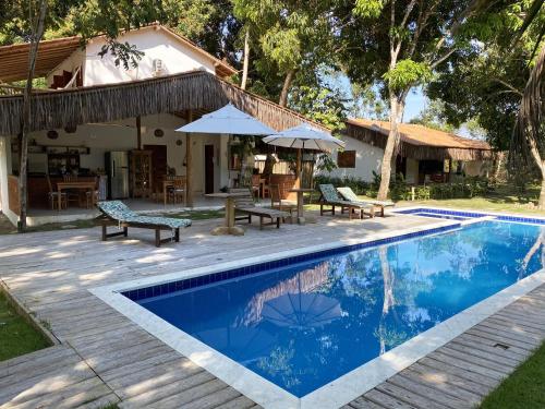 a villa with a swimming pool and a house at Brisa da Bahia in Trancoso