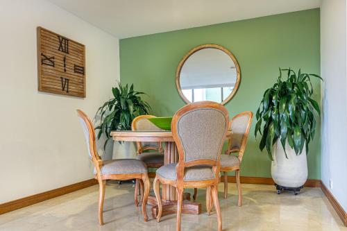 a dining room with a table and chairs and a mirror at Alcazar de Oviedo by EE Hoteles in Medellín