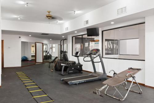 a gym with several tread machines and a flat screen tv at Caracoles Homes in Puerto Peñasco