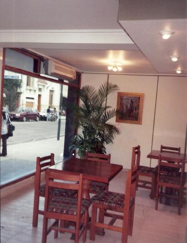 a dining room with a table and chairs and a plant at Hotel Miami in San Miguel de Tucumán