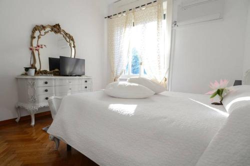 ein weißes Schlafzimmer mit einem weißen Bett und einem Fenster in der Unterkunft FREEDOM in Bellagio