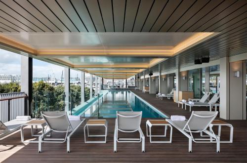 une piscine d'hôtel avec des chaises et une piscine dans l'établissement Park Hyatt Auckland, à Auckland