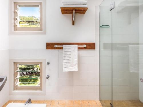a bathroom with a shower with a glass door at Stanwell Beach Glass House in Stanwell Park