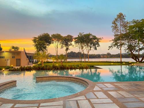a swimming pool with a sunset in the background at River Tree Resort in Chiang Khan