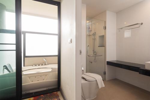a bathroom with a sink and a toilet and a mirror at Romyen Garden Place in Nakhon Ratchasima