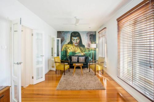 a living room with a painting of a woman at Stunning City Townhouse in Geelong