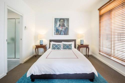 a bedroom with a large bed and a window at Stunning City Townhouse in Geelong