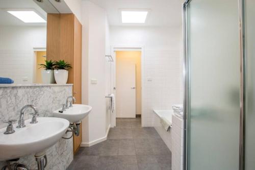a bathroom with two sinks and a shower at Stunning City Townhouse in Geelong